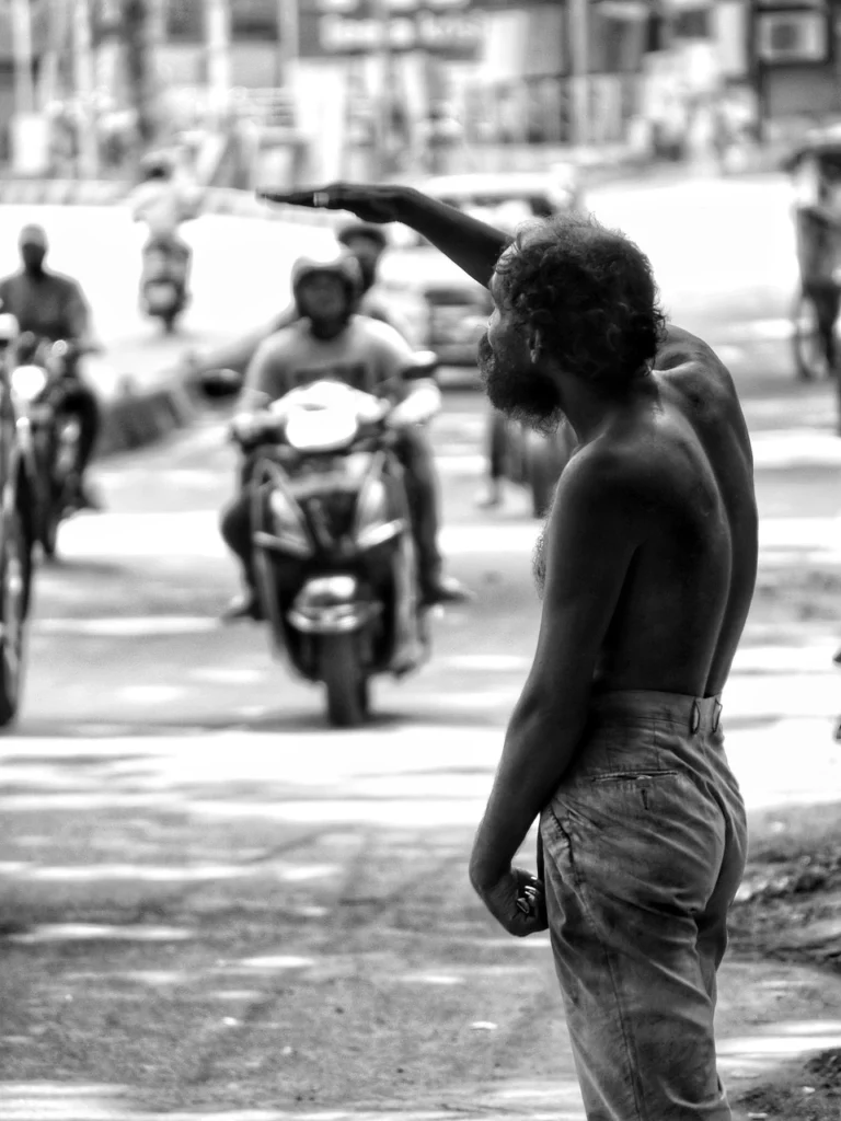 A man standing on an Indian roadside, representing street-level struggles and the need for compassionate social support